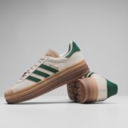 a pair of white and green adidas sneakers